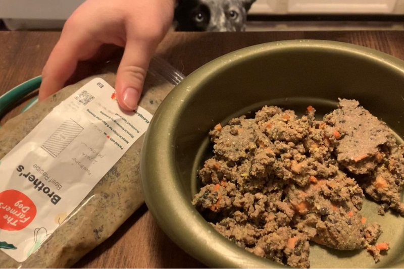 the farmers dog food on the table with dog in the background looking at it